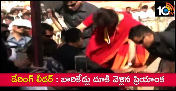Priyanka Gandhi  hops over a barricade to meet supporters during a public meeting