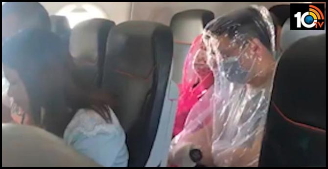 Airline passengers wrap themselves in full-body plastic sheets to fend off coronavirus during Australian flight