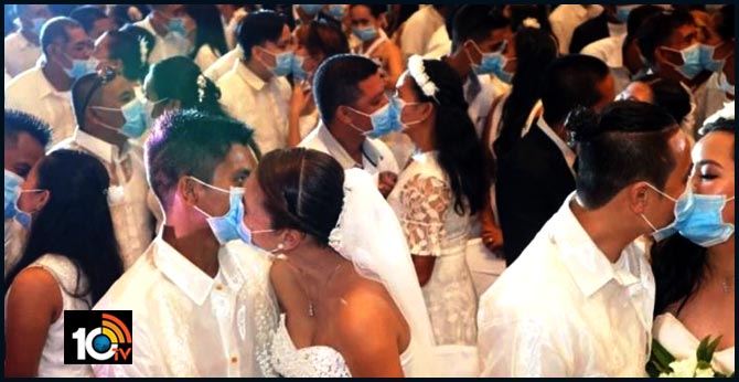Masks and kisses: 220 Philippine new couples exchange kisses with masks