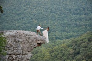 Bride and groom pose for terrifying wedding photoshoot hanging off the edge of a cliff 