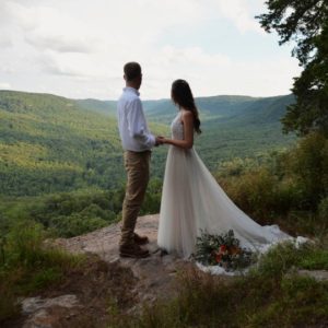 Bride and groom pose for terrifying wedding photoshoot hanging off the edge of a cliff 