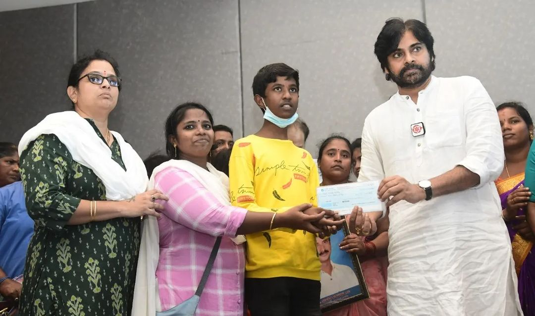 Janasena chief Pawan Kalyan presenting the cheques