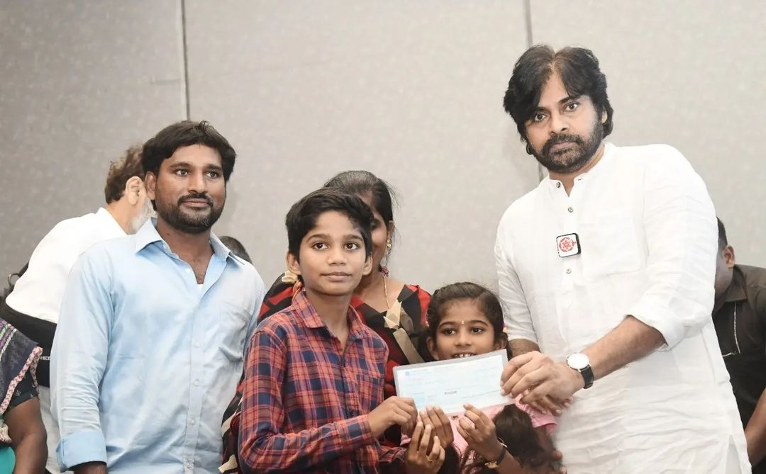 Janasena chief Pawan Kalyan presenting the cheques