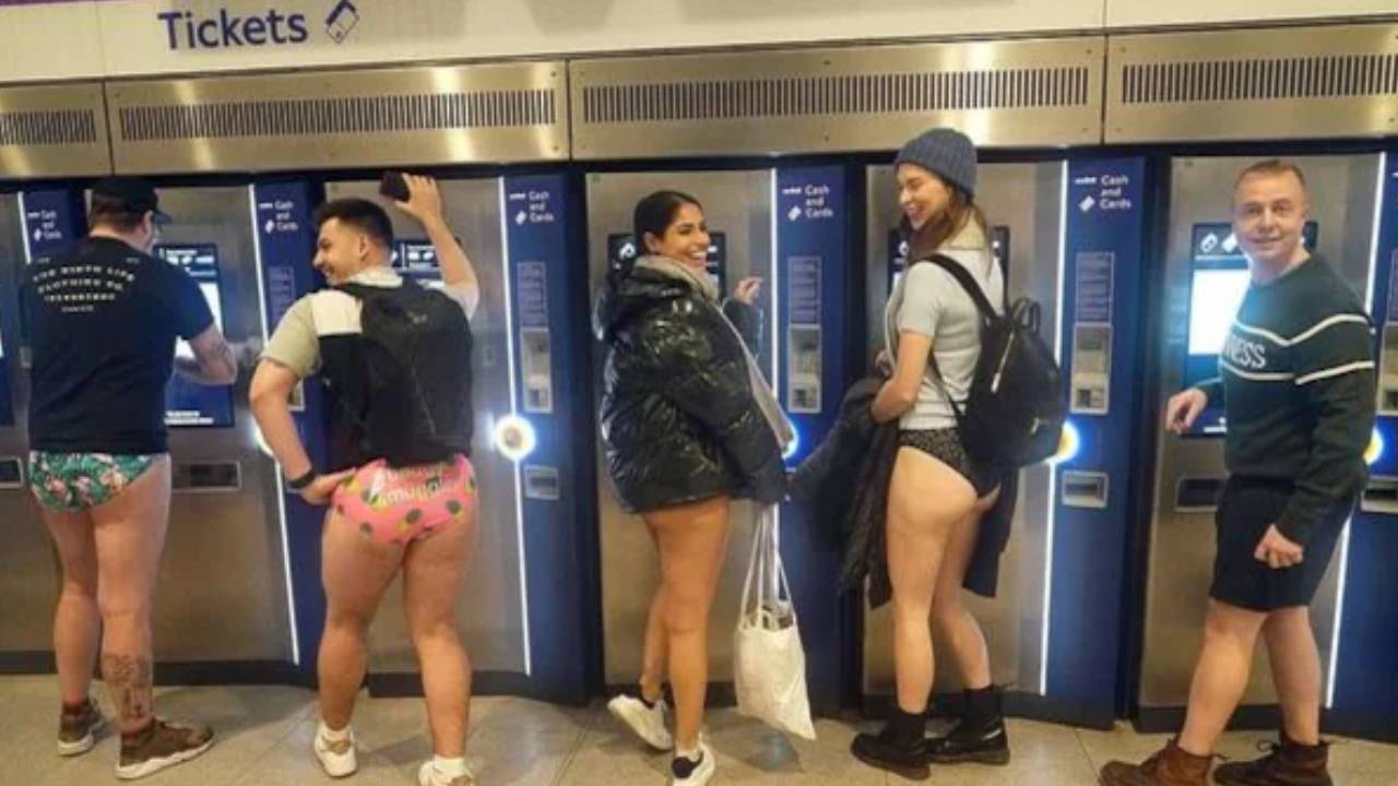 Commuters posing before boarding the no pants tube ride on Monday