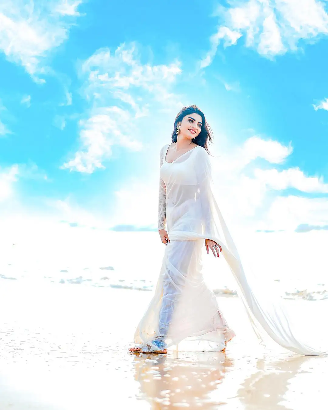 Varsha Sizzling Stills in white Saree at Beach