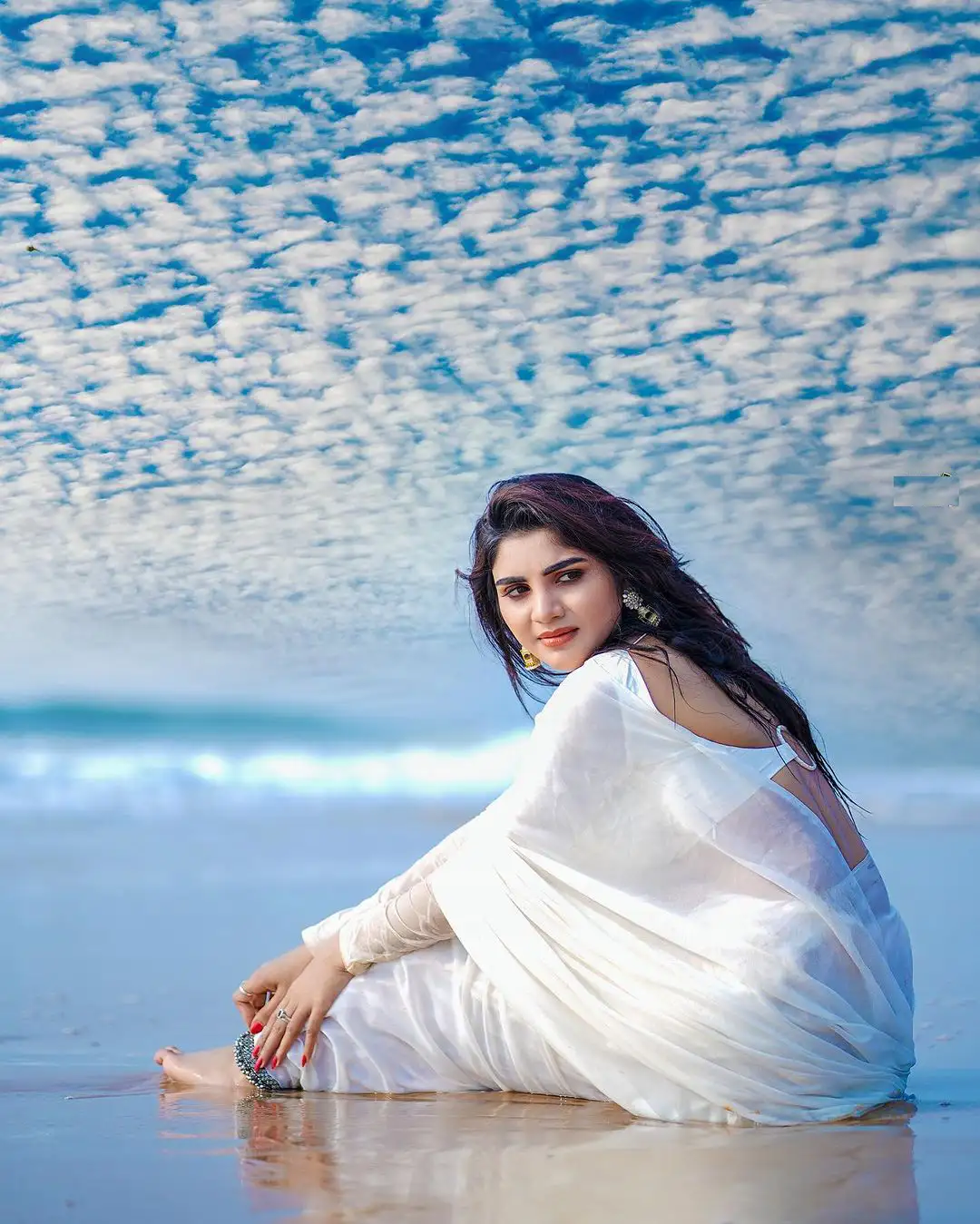 Varsha Sizzling Stills in white Saree at Beach
