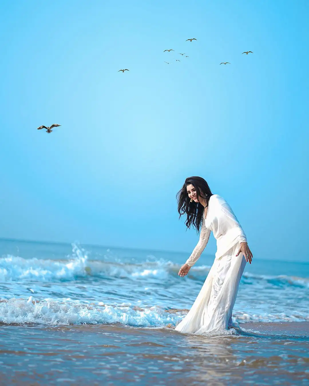 Varsha Sizzling Stills in white Saree at Beach