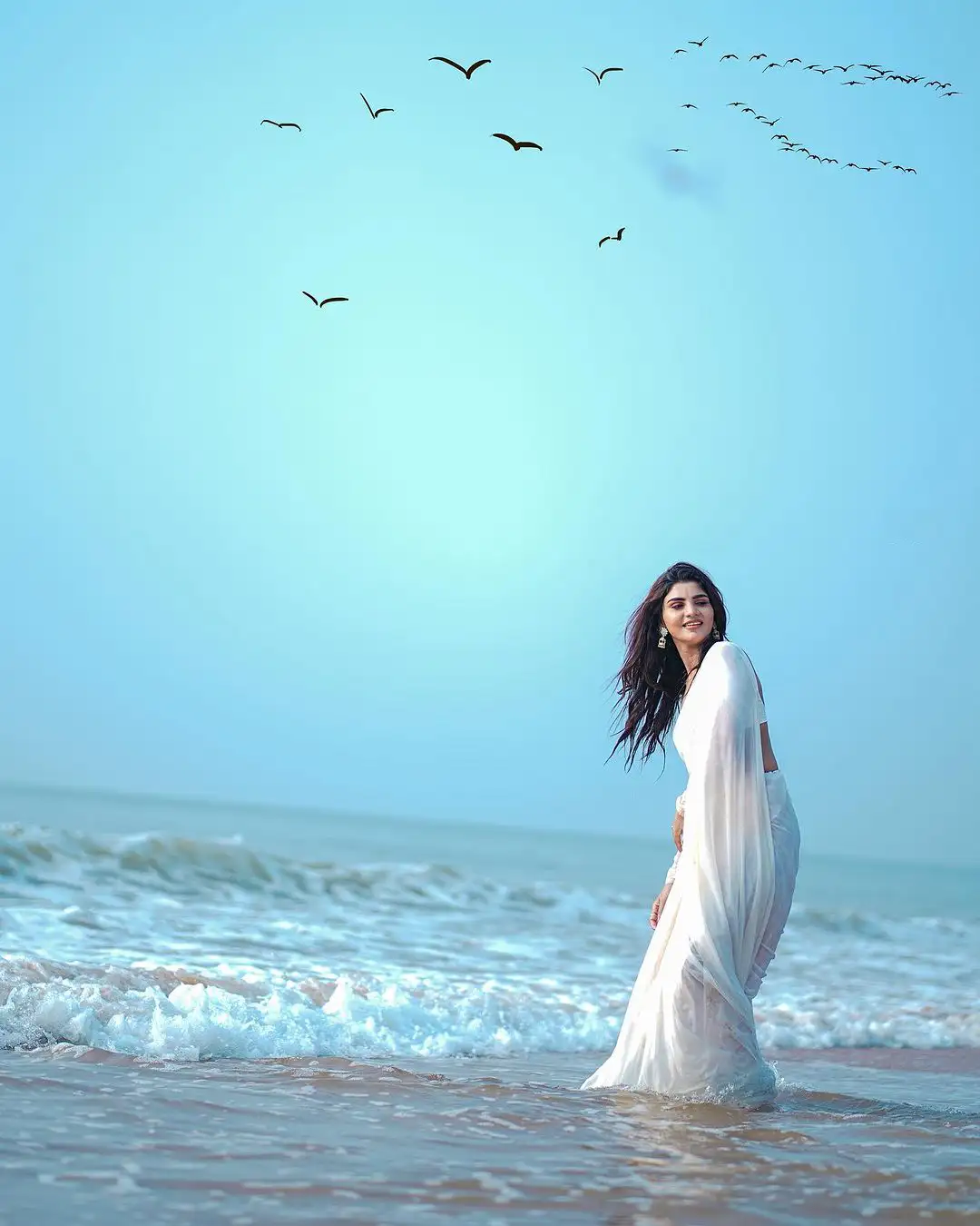 Varsha Sizzling Stills in white Saree at Beach