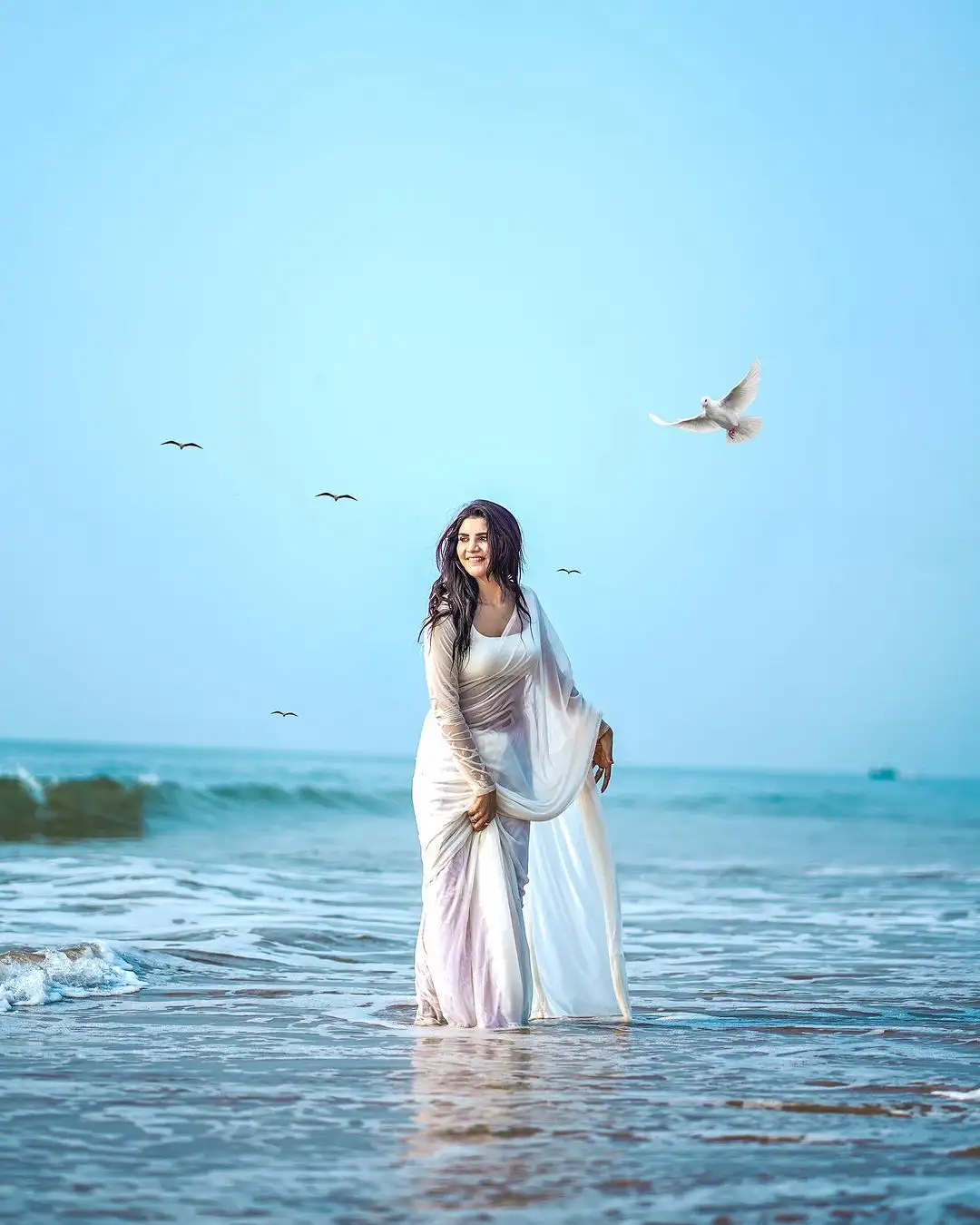 Varsha Sizzling Stills in white Saree at Beach