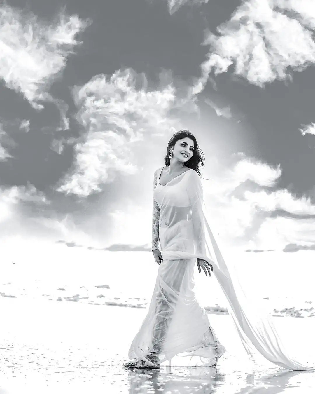 Varsha Sizzling Stills in white Saree at Beach
