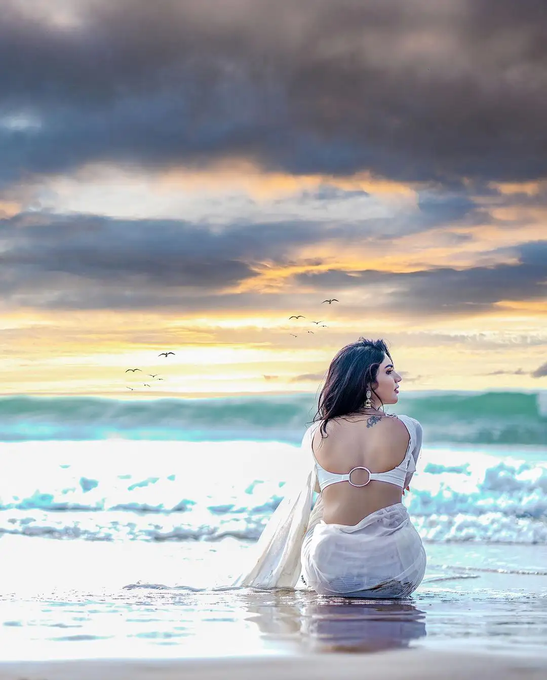 Varsha Sizzling Stills in white Saree at Beach