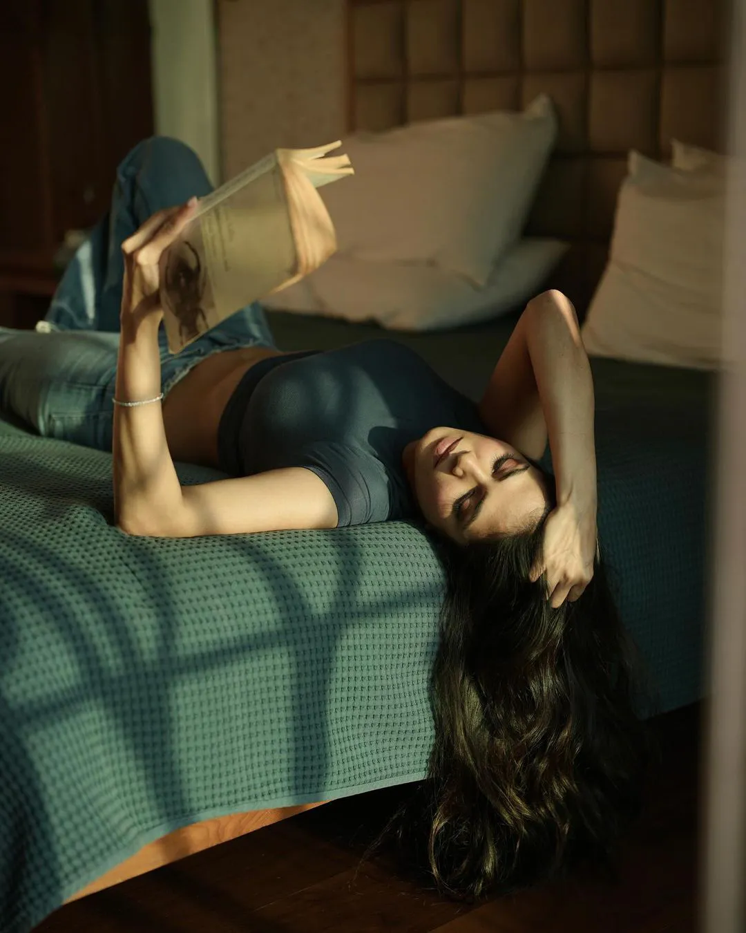Malavika Mohanan Stills with Reading Book on Bed
