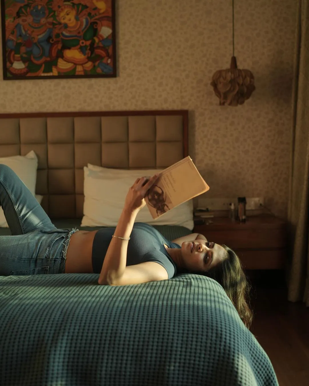Malavika Mohanan Stills with Reading Book on Bed