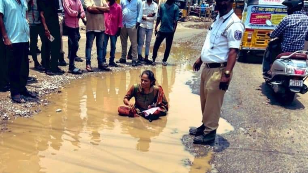 A woman protests against damaged roads
